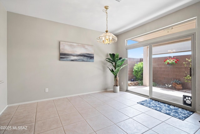 doorway with baseboards, an inviting chandelier, and tile patterned flooring