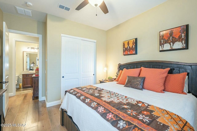 bedroom featuring light wood finished floors, baseboards, visible vents, and a closet