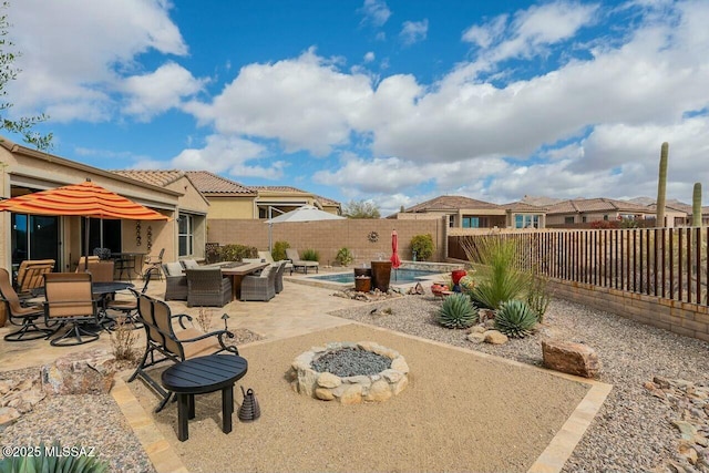 view of patio with a fenced backyard, a fire pit, a fenced in pool, and outdoor dining space