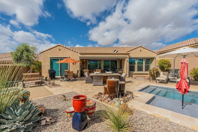 back of house featuring a patio, fence, a tiled roof, and stucco siding