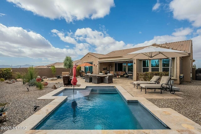 rear view of house with a patio, outdoor lounge area, a fenced backyard, and a fenced in pool