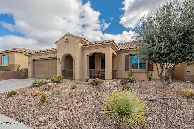 mediterranean / spanish-style house featuring a tile roof, driveway, an attached garage, and stucco siding