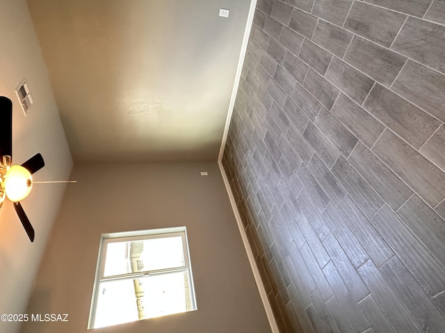 empty room featuring ceiling fan and visible vents