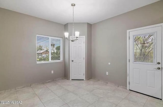 unfurnished dining area featuring a chandelier