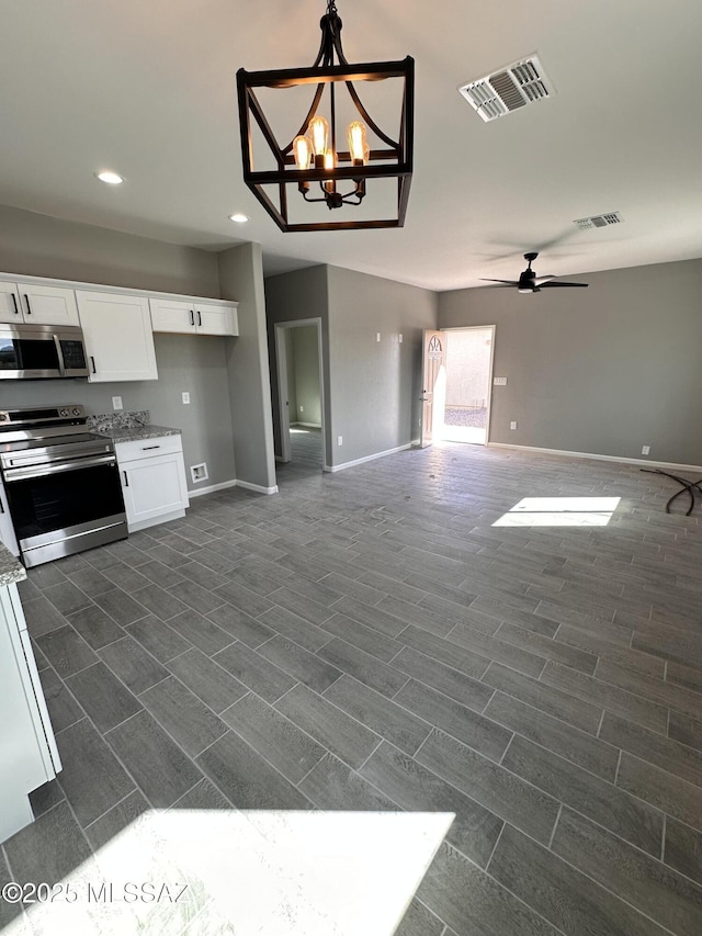 kitchen featuring visible vents, white cabinets, baseboards, appliances with stainless steel finishes, and open floor plan