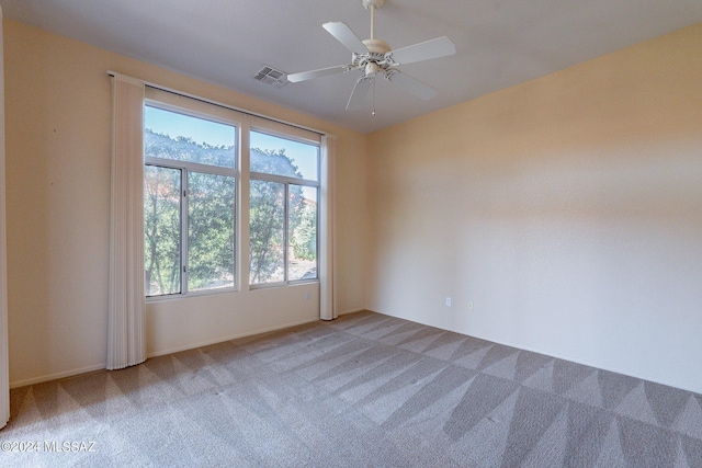 empty room with visible vents, carpet flooring, and a ceiling fan