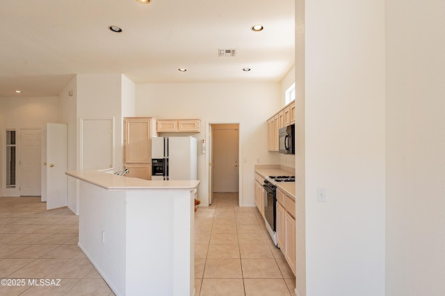 kitchen with light tile patterned floors, light brown cabinets, visible vents, black appliances, and light countertops