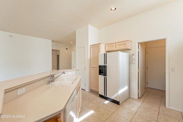 kitchen with light brown cabinets, a sink, white appliances, light countertops, and light tile patterned floors