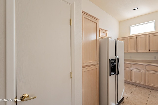 kitchen with light tile patterned floors, light brown cabinets, recessed lighting, light countertops, and white fridge with ice dispenser