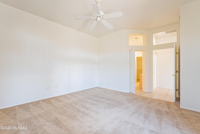 carpeted spare room with tile patterned flooring, visible vents, and ceiling fan