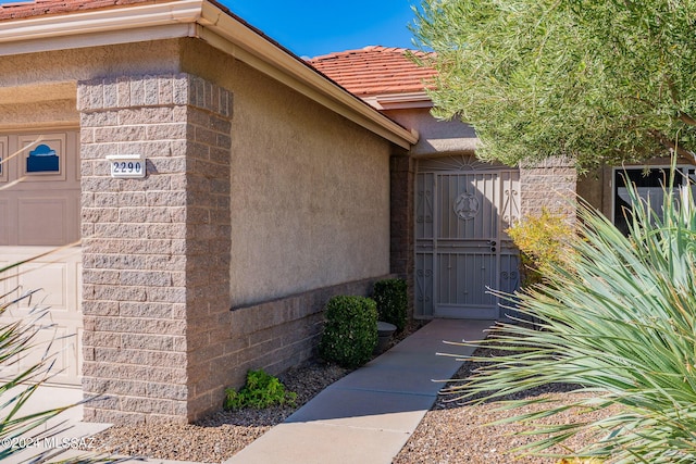 view of exterior entry featuring a tile roof and stucco siding