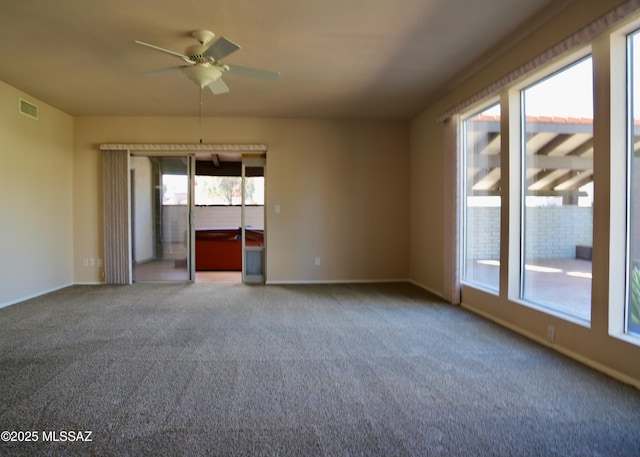 carpeted empty room with a ceiling fan, visible vents, and baseboards