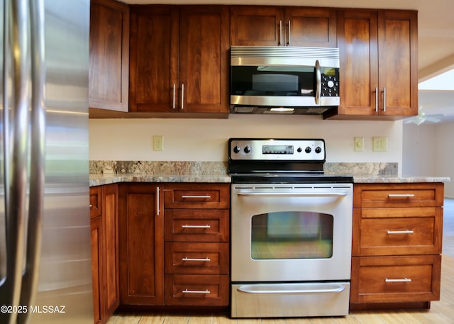 kitchen with light stone counters and appliances with stainless steel finishes