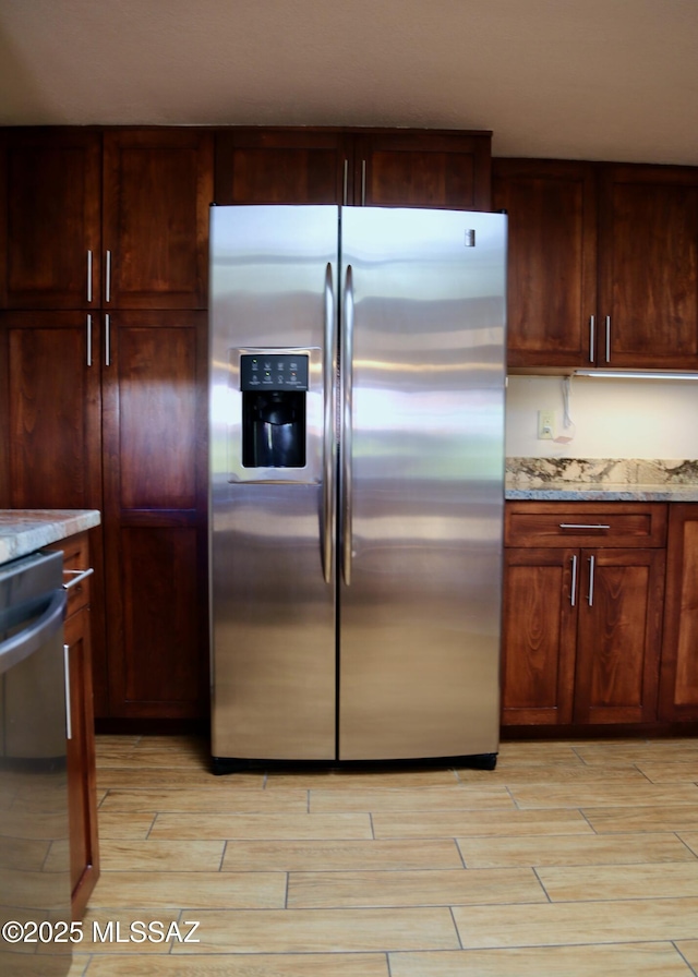 kitchen featuring appliances with stainless steel finishes, light stone countertops, and wood tiled floor