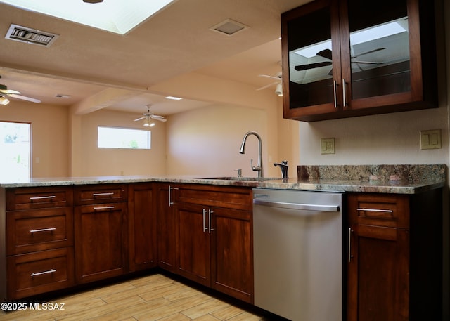 kitchen featuring visible vents, dishwasher, light wood-style floors, a ceiling fan, and a sink