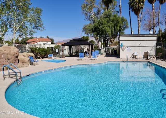 community pool featuring a gazebo, a patio, and fence