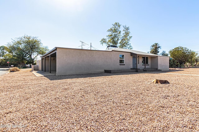 rear view of property featuring stucco siding