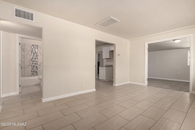 empty room featuring baseboards, visible vents, and wood finish floors