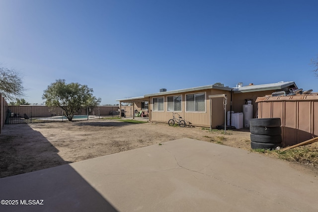 rear view of house with fence and a patio