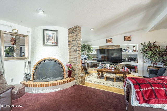 living room featuring carpet, a fireplace with raised hearth, and vaulted ceiling