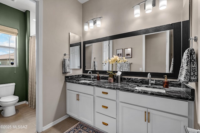 bathroom featuring double vanity, tile patterned flooring, a sink, and toilet