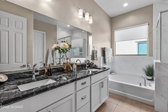 full bathroom featuring a stall shower, tile patterned flooring, a sink, and a bath