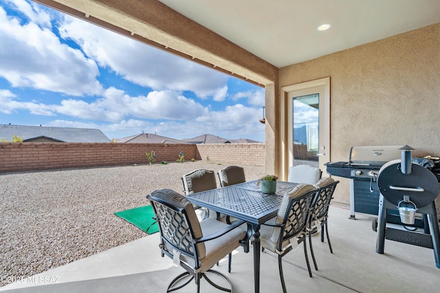 view of patio featuring a fenced backyard, grilling area, and outdoor dining space