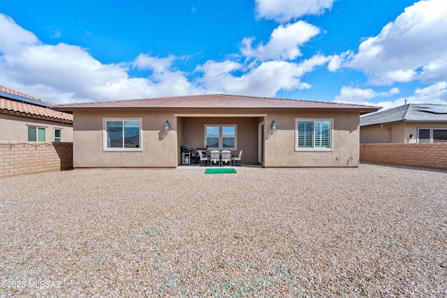 back of house with a fenced backyard, a patio, and stucco siding