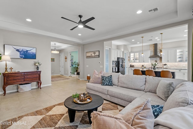 living room featuring recessed lighting, a raised ceiling, visible vents, and light tile patterned floors