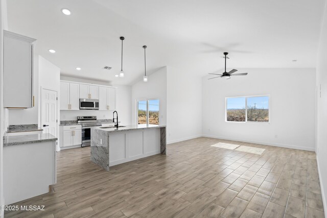 kitchen with visible vents, light wood-style flooring, appliances with stainless steel finishes, open floor plan, and a sink