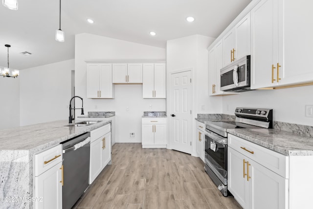 kitchen with appliances with stainless steel finishes, a sink, light wood-style flooring, and white cabinetry