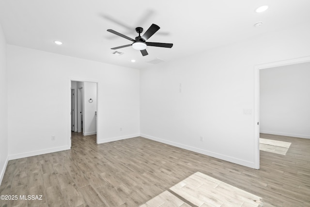 unfurnished room with light wood-type flooring, visible vents, and baseboards