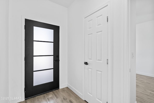 foyer entrance featuring light wood-style floors and baseboards