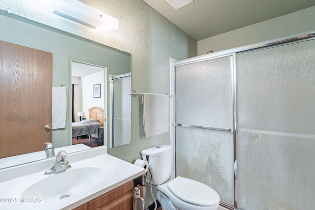 ensuite bathroom featuring toilet, visible vents, vanity, a shower stall, and ensuite bath