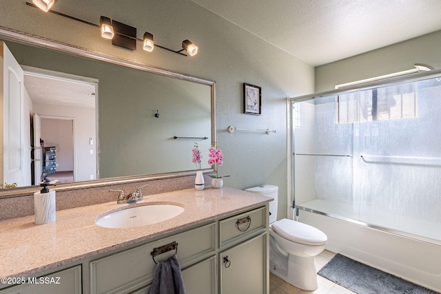 full bathroom with combined bath / shower with glass door, vanity, toilet, and a textured ceiling