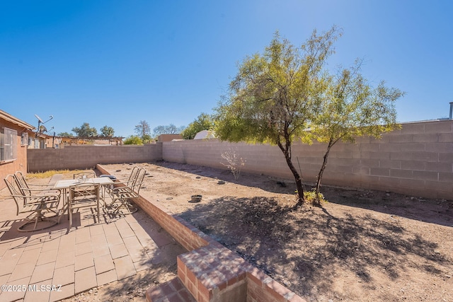 view of yard with outdoor dining space, a patio area, and a fenced backyard