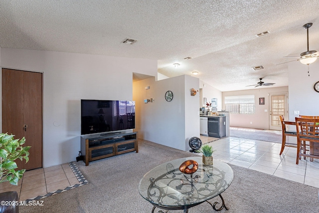 living room featuring visible vents, vaulted ceiling, light carpet, and light tile patterned floors