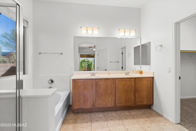 full bathroom featuring tile patterned floors, a bath, double vanity, and a sink