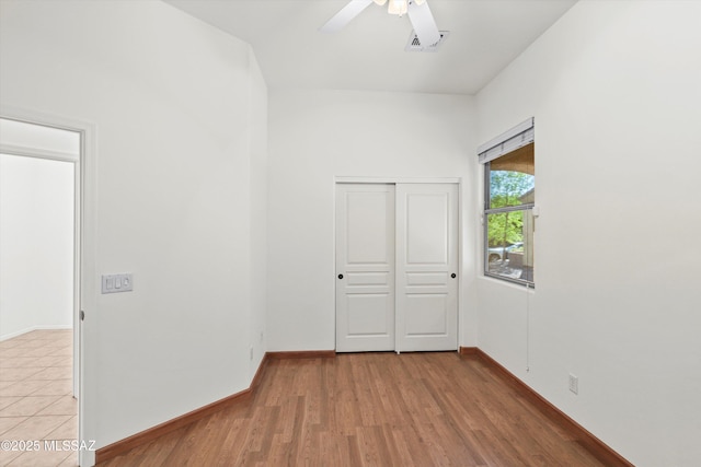 spare room featuring visible vents, a ceiling fan, light wood-type flooring, and baseboards