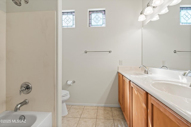 bathroom featuring tile patterned flooring, double vanity, toilet, and a sink