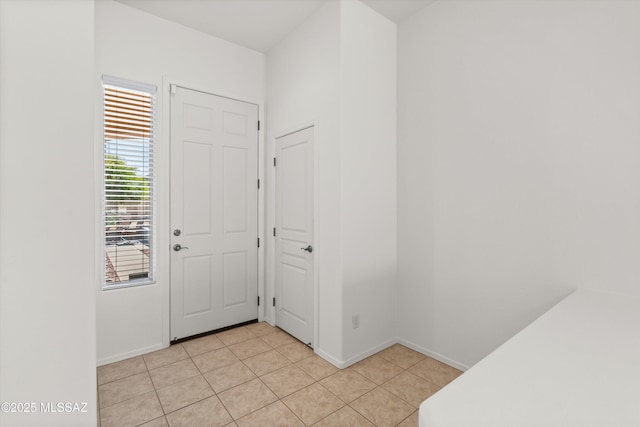 entrance foyer featuring light tile patterned floors and baseboards