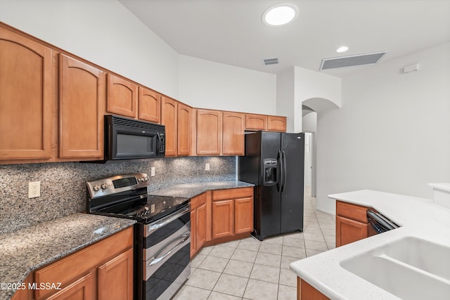 kitchen with decorative backsplash, black appliances, light tile patterned floors, and visible vents