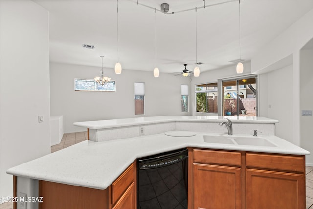 kitchen featuring brown cabinetry, visible vents, a sink, dishwasher, and decorative light fixtures