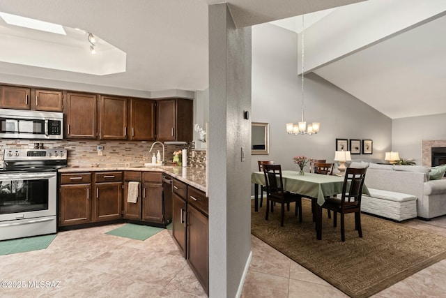 kitchen with a sink, dark brown cabinets, backsplash, and stainless steel appliances