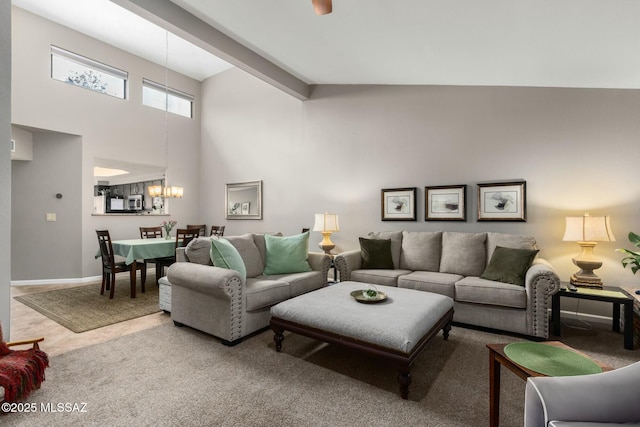 living room with baseboards, a notable chandelier, a high ceiling, and carpet