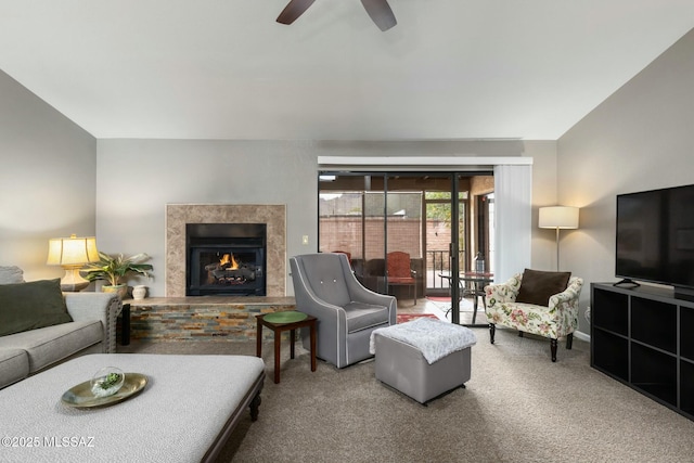 carpeted living area featuring a high end fireplace and a ceiling fan