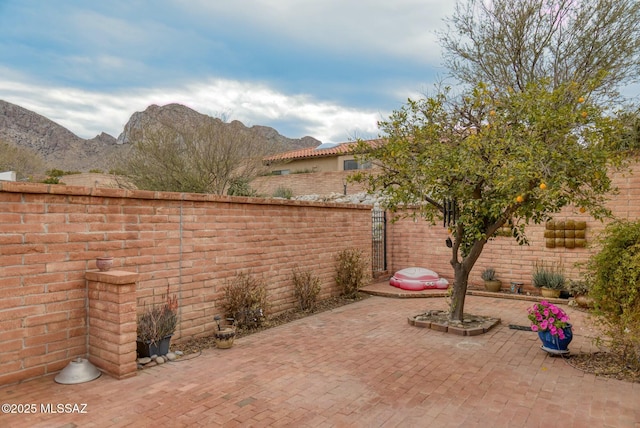 view of patio / terrace with a mountain view and a fenced backyard