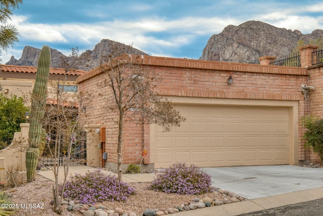 view of front of property with brick siding, a mountain view, driveway, and a garage