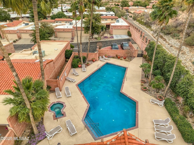 community pool with a patio area and a hot tub