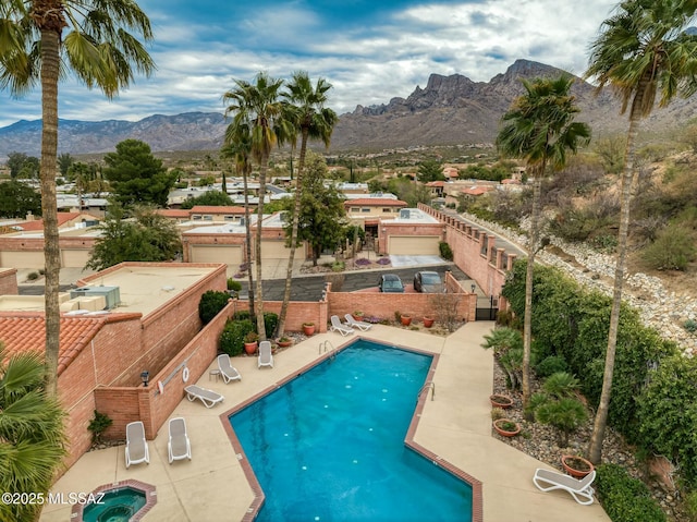 pool with a patio, a fenced backyard, and a mountain view